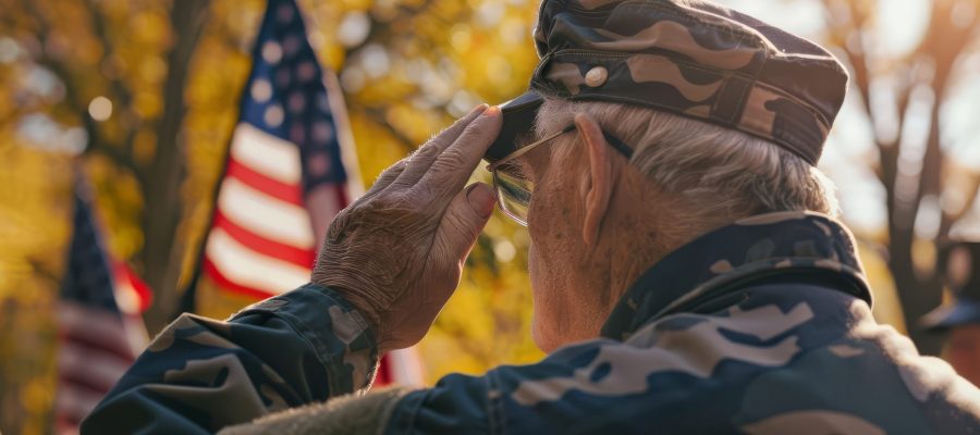 Elderly veteran saluting in uniform with American flags in the background during a sunny day, honoring military service.